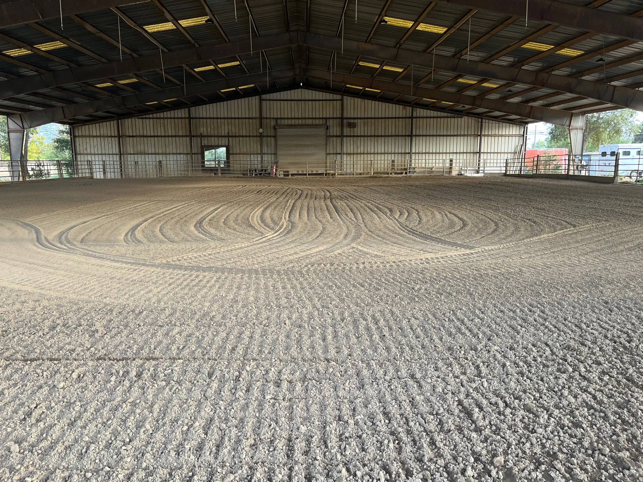 The covered arena with freshly groomed sand footing